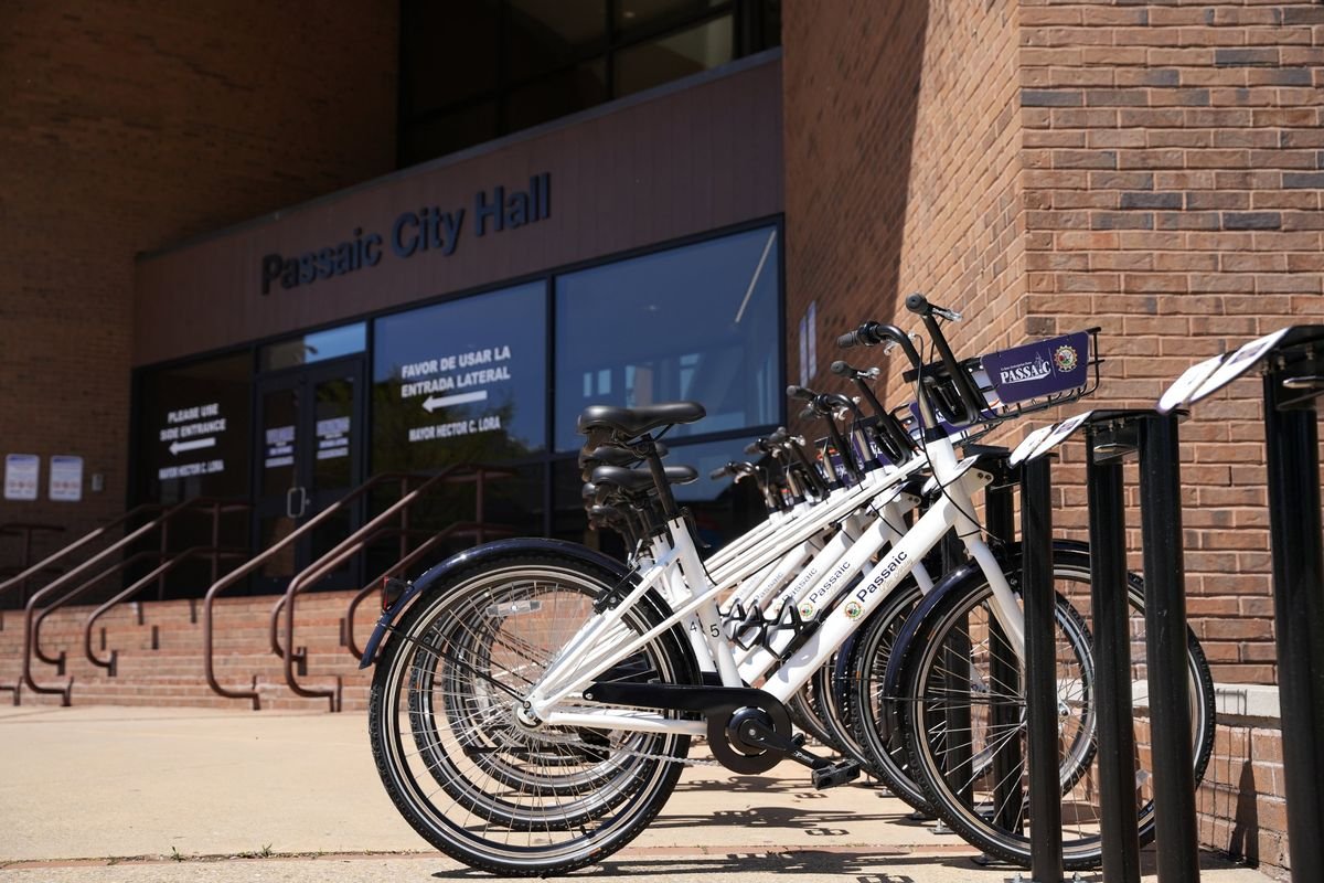 White Passaic bike share bikes docked at the station outside Passaic City Hall.