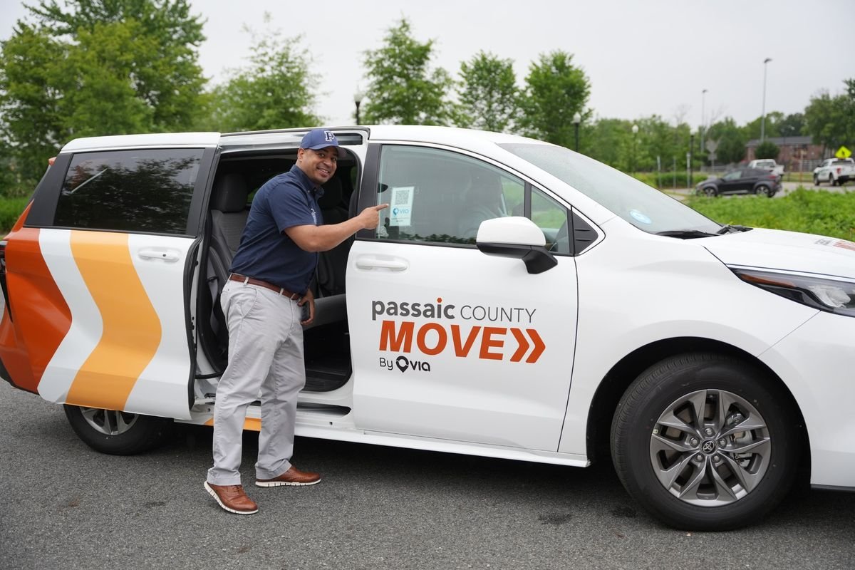 A Passaic County MOVE minivan with its door open, showing the QR code used to book a ride.