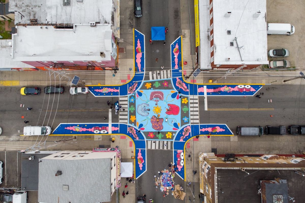 Aerial view of the painted intersection at Monroe Street and Columbia Avenue, with colorful curb extensions and a central mural.